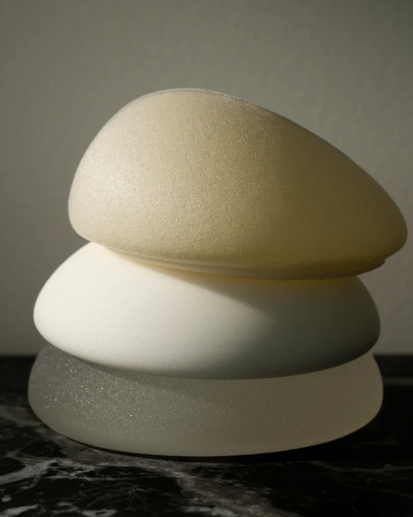 Cirurgião plástico avaliando as mamas de uma paciente durante consulta para indicar mastopexia ou prótese de silicone.